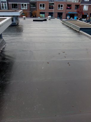 foto van een duurzaam ECB dakin de kleur zwart  deze bedekking gaat zeker 50 jaar mee met al 45 jaar oude referenties te zien is ook de fraaie zinken dakrandafwerking